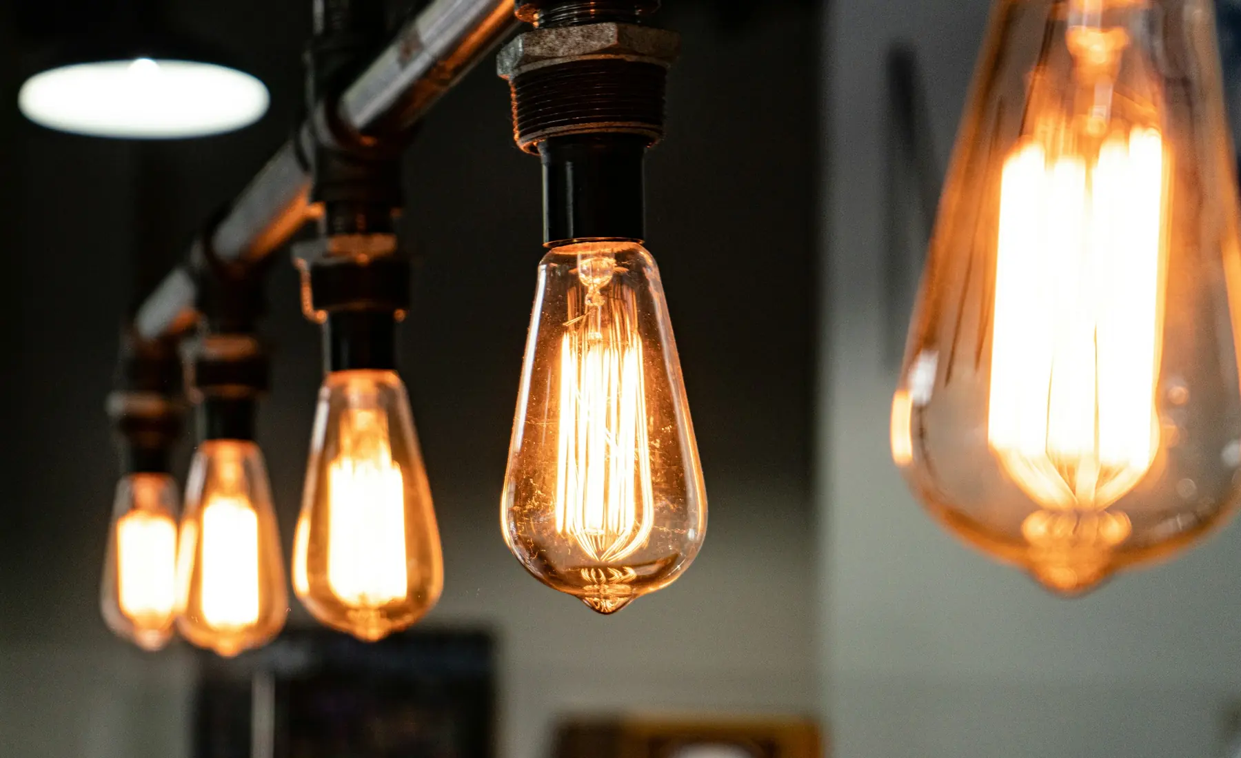 A row of warm filament bulbs glowing on a dark wall